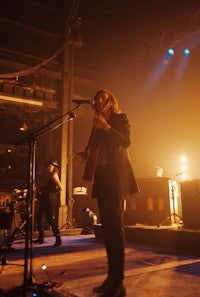 a man in a suit standing on stage with a microphone