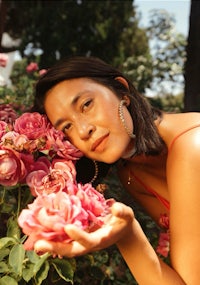 a woman in a pink dress posing with roses