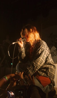 a person singing into a microphone in front of a crowd