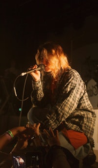 a person singing into a microphone in front of a crowd