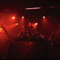 a man standing on top of a stage with red lights