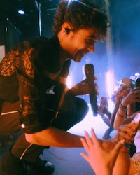 a man holding a microphone in front of a crowd of people