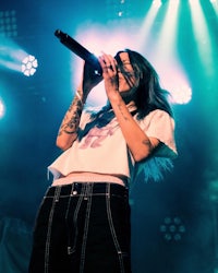 a woman singing into a microphone on stage