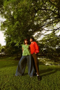 a man and a woman posing for a picture in a park