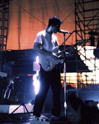 a man standing on stage with a guitar