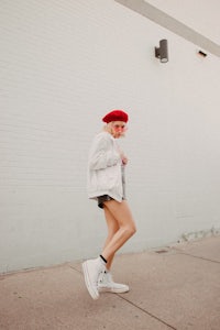 a woman wearing a red beret and white shorts